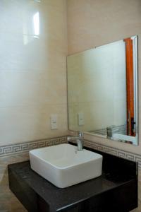 ein Badezimmer mit einem weißen Waschbecken und einem Spiegel in der Unterkunft LUXURY HOSTEL in Ha Giang