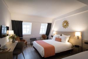 een hotelkamer met een bed en een bureau bij Hotel Rohan, Centre Cathédrale in Straatsburg