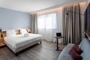 pokój hotelowy z łóżkiem i laptopem na stole w obiekcie Novotel Parma Centro w mieście Parma