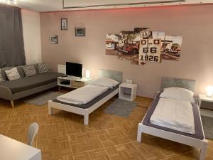 a living room with two beds and a couch at AschaffApartment 4 Schlafzimmer bis 10 Personen bei Aschaffenburg in Mainaschaff