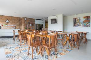 a dining room with wooden tables and chairs at OYO Tropical Confort Hotel, Brasilia in Brasilia