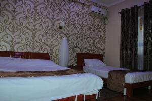 a hotel room with two beds and a wallpaper at Хотел Хесон in Khujand