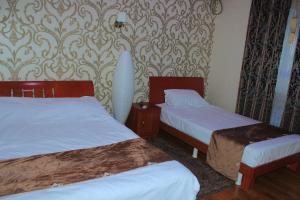 a hotel room with two beds and a wallpaper at Хотел Хесон in Khujand