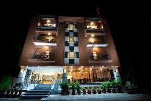 Un grand bâtiment avec des lumières allumées la nuit dans l'établissement ABM Boutique Hotel by Purple Cloud, à Bangalore