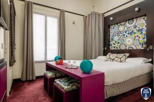sypialnia z dużym łóżkiem i purpurowym stołem w obiekcie Courcelles Etoile w Paryżu