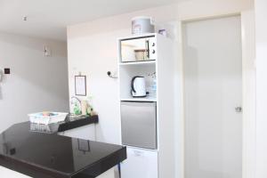 a kitchen with white walls and a black counter at One O' Three Studio Apartment @D'Perdana Kota Bharu in Kota Bharu