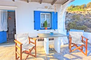 a dining room with a blue table and chairs at Sifnos Residence in Platis Gialos