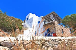 a house on a hill with a stone yard at Sifnos Residence in Platis Gialos