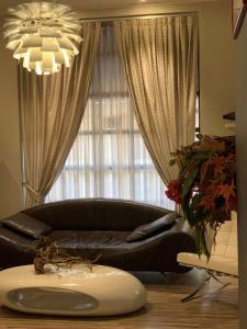 a black leather couch in a living room with a window at Hotel Stella in Modena