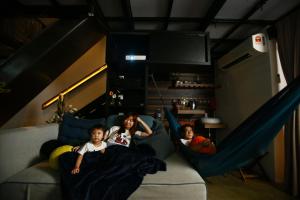 two children laying on a couch in a room at Private Getaway (Private Cinema, Swing & more!) at CEO Penang in Bayan Lepas +2 photos