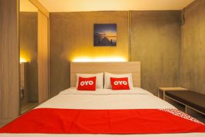 1 dormitorio con 1 cama grande y 2 almohadas rojas en OYO 75368 Demadre Resort, en Ban Ko