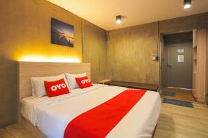 ein Schlafzimmer mit einem großen Bett mit roten Kissen in der Unterkunft OYO 75368 Demadre Resort in Ban Ko