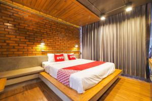 Un dormitorio con una cama con almohadas rojas. en OYO 75368 Demadre Resort, en Ban Ko