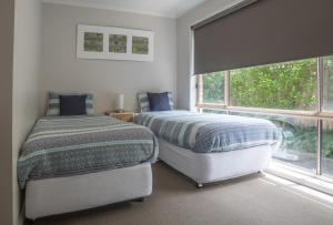 a bedroom with two beds next to a window at Mornington Peninsula-4Shore Rosebud in Rosebud
