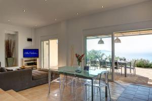 Una sala de estar con una mesa de cristal y un sofá. en Villa Portokali, en Sivota