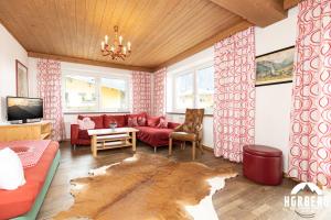 a living room with a red couch and a table at HORBERG Appartements in Schwendau