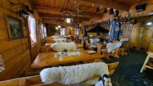 a room with sheep chairs and tables in a building at Hotel Koliba in Senec