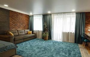 a living room with a couch and a large window at Apartament on Sovetskaya 80 in Bobruisk