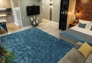 Un dormitorio con una cama y una gran alfombra azul en Apartament on Sovetskaya 80, en Babruisk