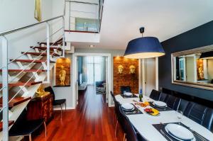 a dining room with a table and chairs and a staircase at Victoria City Center Barcelona in Barcelona