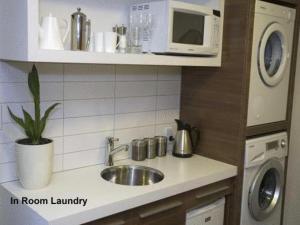 a kitchen counter with a sink and a microwave at Terra Vive Suites & Apartments in Christchurch