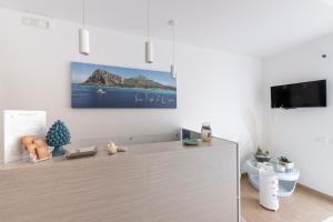 a white kitchen with a tv on a wall at La Nicchia in San Vito lo Capo