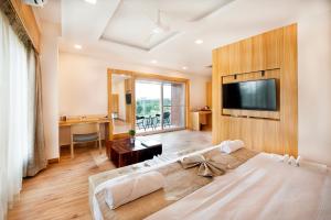 a bedroom with a large bed with a flat screen tv at ABM Boutique Hotel by Purple Cloud in Bangalore