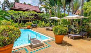 einen Pool mit Stühlen und Sonnenschirmen in einem Resort in der Unterkunft Ban Keaw Villas in Bophut 