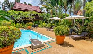 a pool with chairs and umbrellas in a resort at Ban Kaew Villas in Bophut 