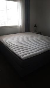 Una cama grande en un dormitorio con ventana. en Leviraitti 4 A2, en Kittilä