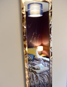 um espelho num quarto com uma cama e um candeeiro em 2 Bedroom Apartment -Sleeps 4- Big Savings On Long Stays! em Canterbury