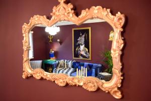 um espelho numa parede com um sofá azul num quarto em 2 Bedroom Apartment -Sleeps 4- Big Savings On Long Stays! em Canterbury