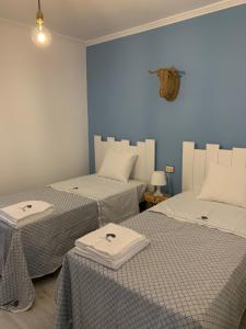 - 2 lits dans une chambre aux murs bleus dans l'établissement Casa da Oliveira, à Poio
