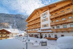 a large building with snow on the ground at Hotel Sonnhof in Neustift im Stubaital