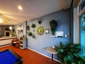 uma sala de estar com uma parede azul com um relógio e plantas em AT home hotel em Hua Hin