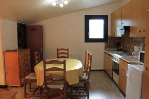 una cocina con mesa y algunas sillas y una mesa y una cocina con en Cosy Studio Near The Slopes In Chamonix, en Chamonix-Mont-Blanc