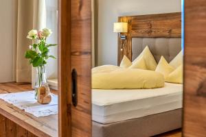a bedroom with a bed and a vase of flowers on a table at Hotel Sonnhof in Neustift im Stubaital