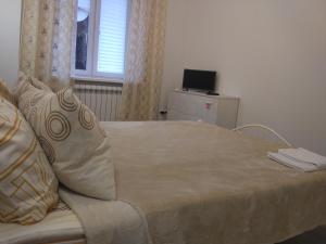 um quarto com uma cama, uma janela e uma televisão em Apartment на Полковой в центре em Omsk