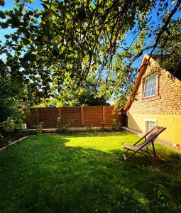 a wooden bench sitting in the grass in a yard at The Nook - Balatonkiliti in Siófok