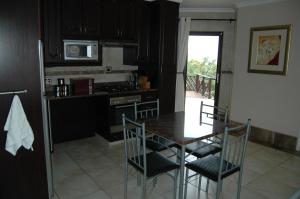 a kitchen with a table and chairs and a stove at Bon A Vie Self-catering and b&b Gonubie Full Solar Power, no load shedding! in Gonubie