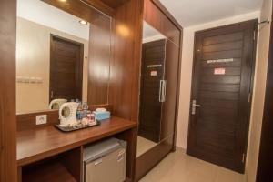 La salle de bains est pourvue d'une coiffeuse en bois et d'un miroir. dans l'établissement Hotel Puri Nusa Indah, à Denpasar