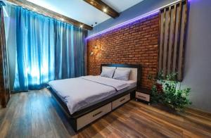 a bed in a room with a brick wall at Apartament on Gorkogo 23 in Bobruisk