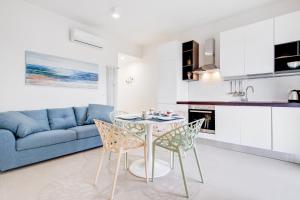 ein Wohnzimmer mit einem blauen Sofa, einem Tisch und Stühlen in der Unterkunft Vista su San Luca Apartment in Bologna