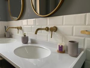 een badkamer met een witte wastafel en 2 spiegels bij Dragonfly Residence in Belgrado +63 foto's