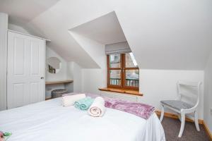 a bedroom with a white bed and a chair at Innes Street Apartments in Inverness