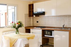 una cucina con tavolo e vaso di fiori di Residence Il Borgo a Tortoreto