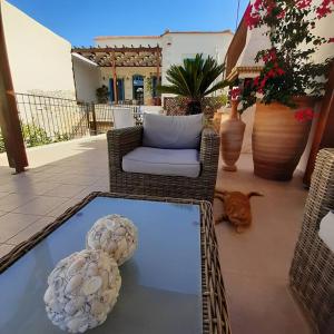 a patio with a couch and a glass table at Villa Aposperitis in Panormos Rethymno