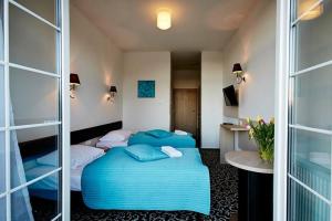 a hotel room with two beds with blue pillows at Zajazd Europa in Borki Wyrki