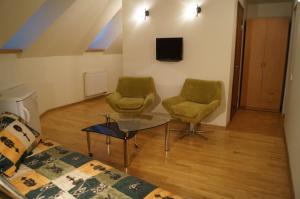 a living room with two chairs and a table at Meškių dvarkiemis in Šiauliai