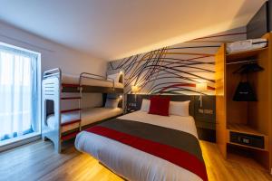 - une chambre avec un lit et des lits superposés dans l'établissement Sleeperz Hotel Cardiff, à Cardiff